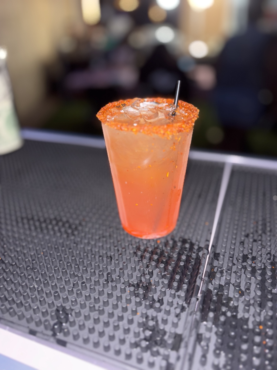 Coral-colored cocktail with a bright citrus rim